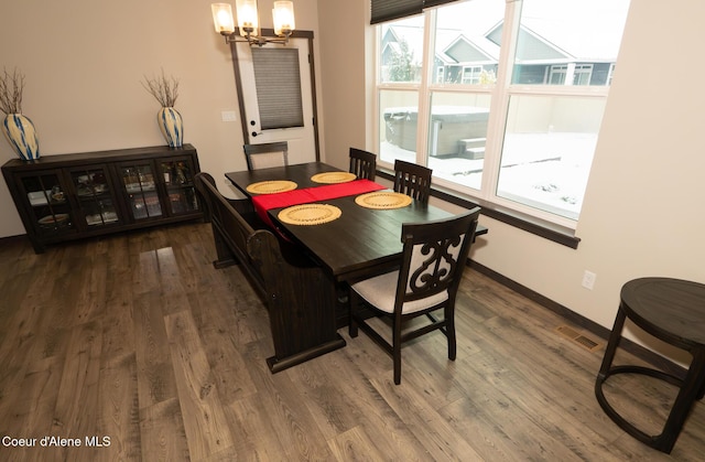 dining area featuring an inviting chandelier and hardwood / wood-style flooring