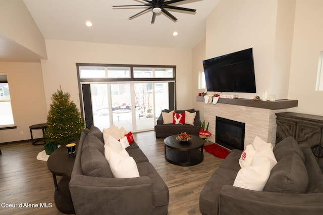 living room with dark hardwood / wood-style floors, ceiling fan, plenty of natural light, and a tiled fireplace