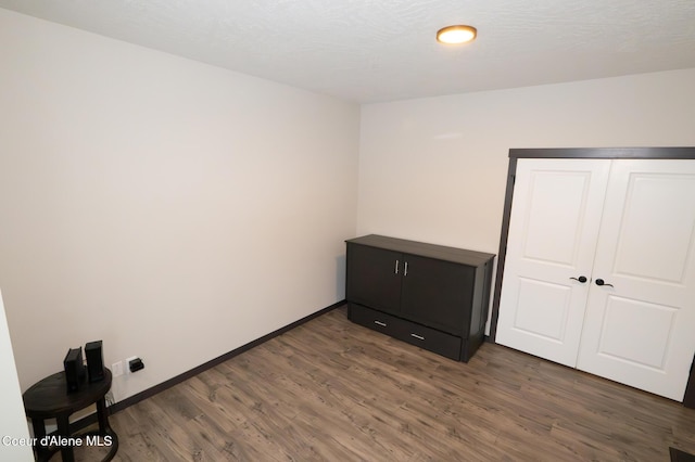 unfurnished bedroom with a closet and dark wood-type flooring