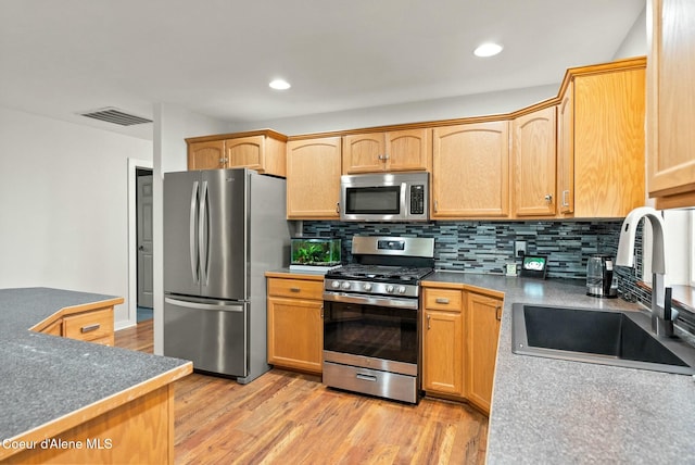 kitchen featuring sink, stainless steel appliances, light hardwood / wood-style flooring, decorative backsplash, and light brown cabinetry