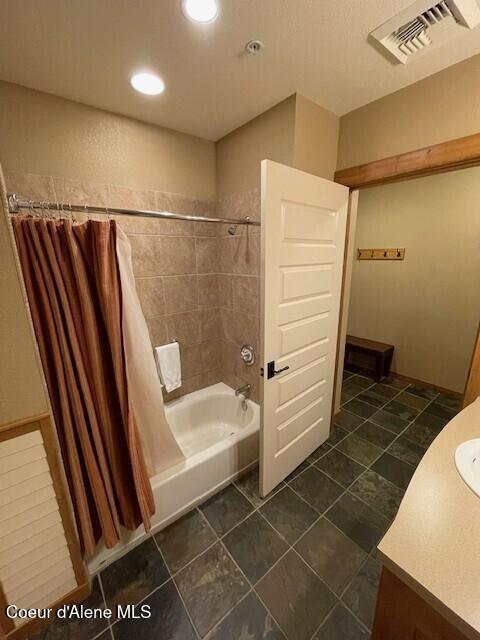 bathroom featuring tile patterned flooring, vanity, and shower / tub combo