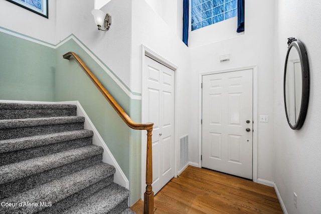 entryway featuring a towering ceiling and hardwood / wood-style flooring