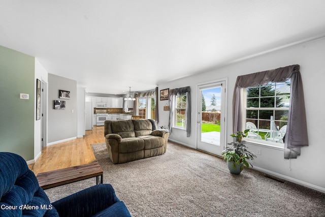 living room with light hardwood / wood-style flooring and a notable chandelier