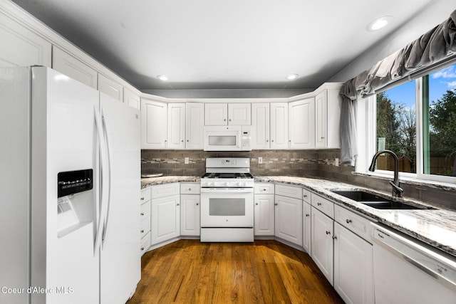 kitchen featuring dark hardwood / wood-style flooring, backsplash, white appliances, sink, and white cabinetry