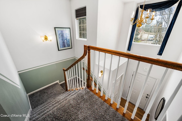 stairs with a notable chandelier and wood-type flooring