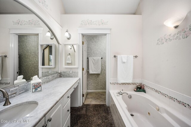 bathroom featuring tile patterned floors, vanity, and tiled tub