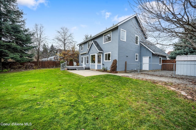 back of property with a deck, a yard, and a patio