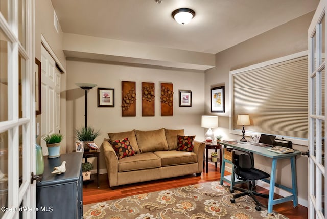 office with hardwood / wood-style flooring and french doors