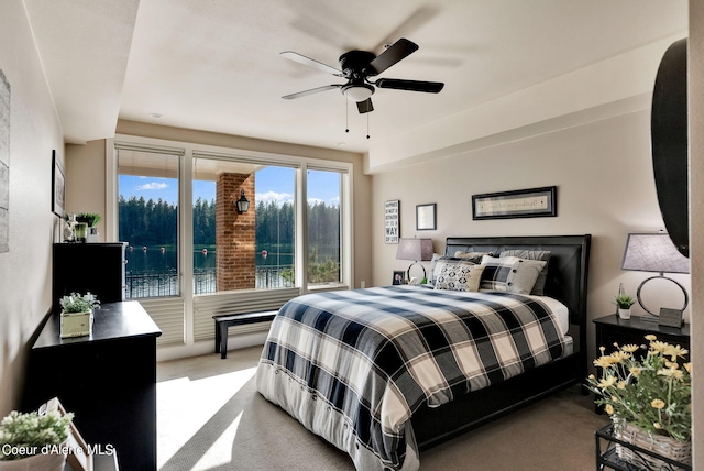 bedroom featuring ceiling fan, a water view, and light colored carpet