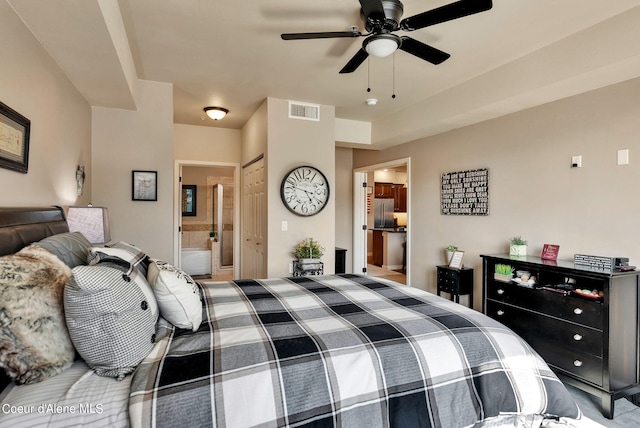 bedroom featuring ceiling fan, stainless steel fridge, and ensuite bath