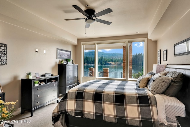 carpeted bedroom with ceiling fan and a water view