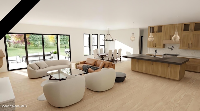 living room with light hardwood / wood-style floors, sink, and a chandelier