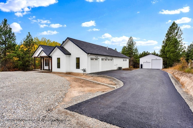 view of front of house with central AC, an outbuilding, and a garage