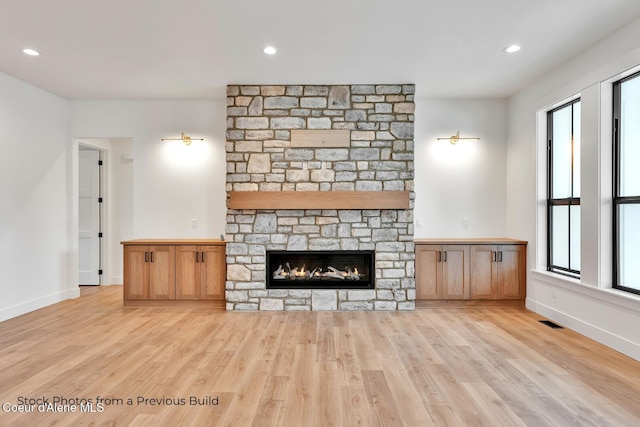 unfurnished living room with light wood-type flooring and a fireplace