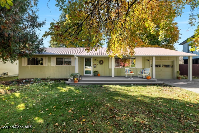 ranch-style home featuring a front yard, a porch, and a garage