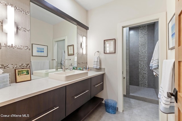 bathroom featuring tile patterned flooring, vanity, and tiled shower