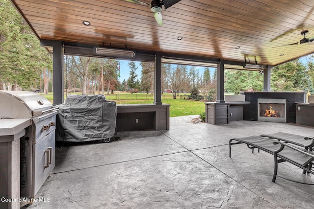 view of patio featuring an outdoor kitchen, area for grilling, ceiling fan, and exterior fireplace