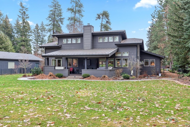 rear view of house featuring a lawn