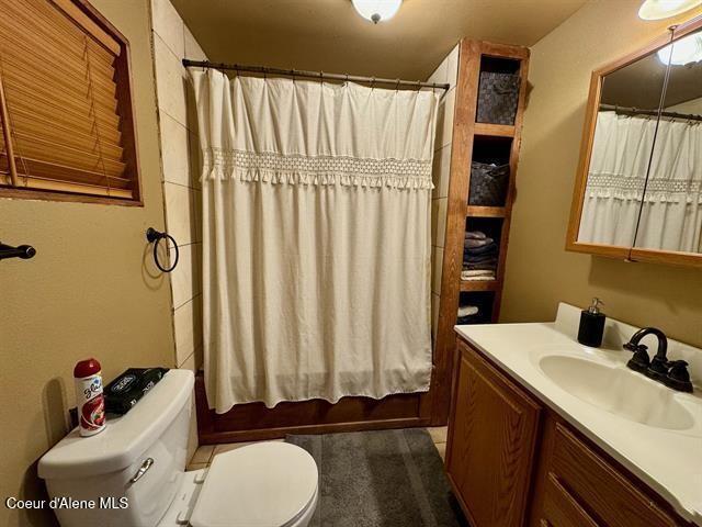 full bathroom featuring shower / tub combo, vanity, and toilet