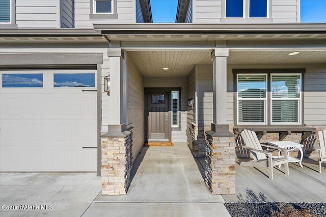 property entrance with covered porch and a garage