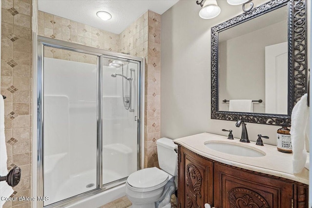 bathroom featuring a shower with door, vanity, a textured ceiling, and toilet