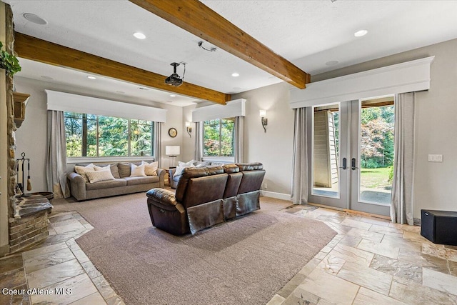 living room with beam ceiling, a wealth of natural light, and french doors