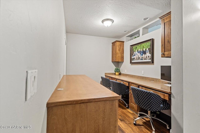 office area with light hardwood / wood-style floors and a textured ceiling