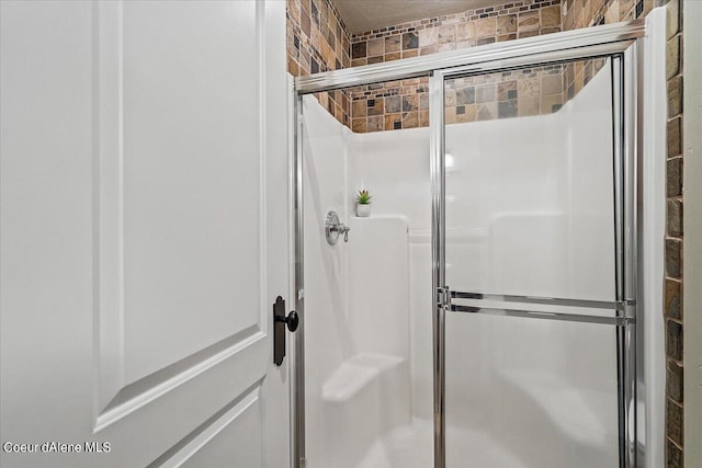 bathroom with a shower with door