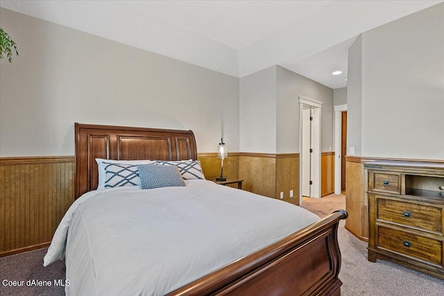 carpeted bedroom with wood walls