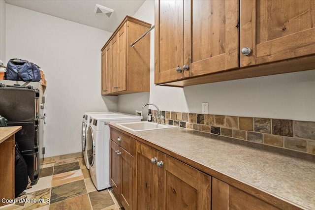 washroom with washing machine and dryer, sink, and cabinets