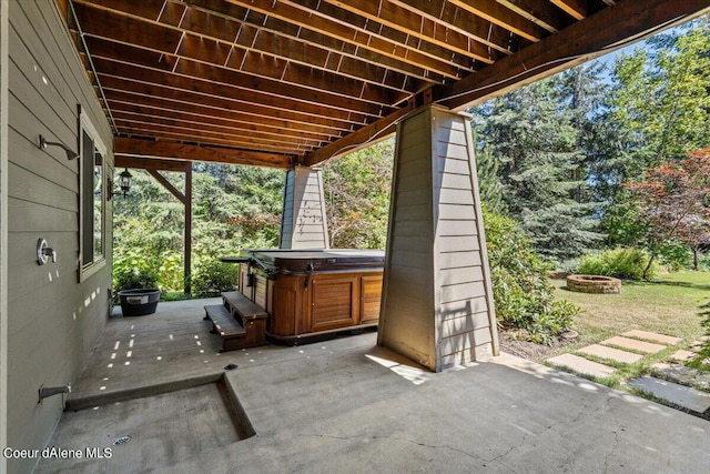 view of patio / terrace with a fire pit and a hot tub