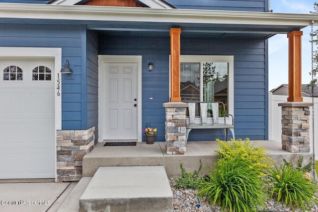 entrance to property featuring covered porch and a garage