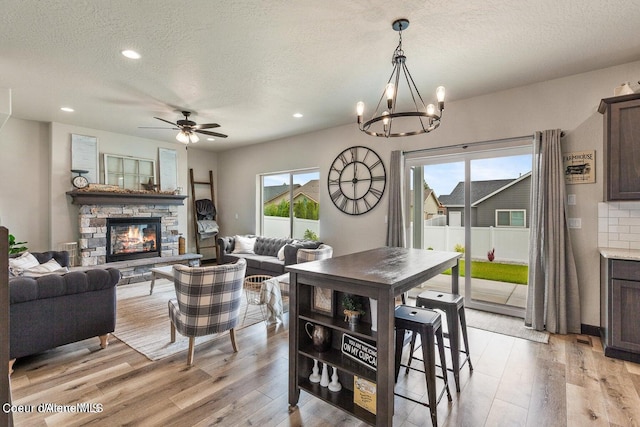 dining space featuring plenty of natural light, a textured ceiling, and light wood-type flooring