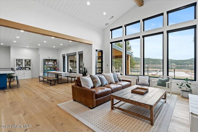 living room featuring beam ceiling, light hardwood / wood-style flooring, and high vaulted ceiling