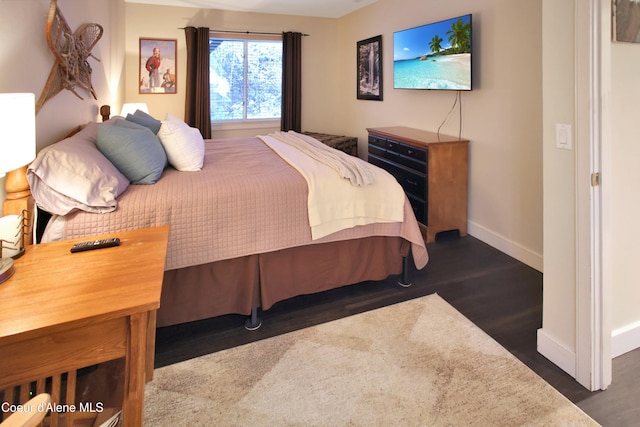 bedroom featuring dark wood-style flooring and baseboards