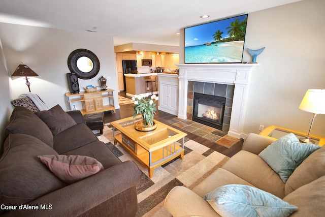 living area with recessed lighting, a fireplace, and wood finished floors