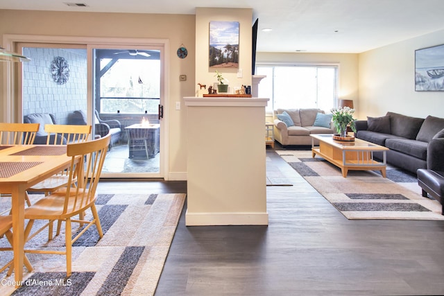 living room with wood finished floors, visible vents, and baseboards