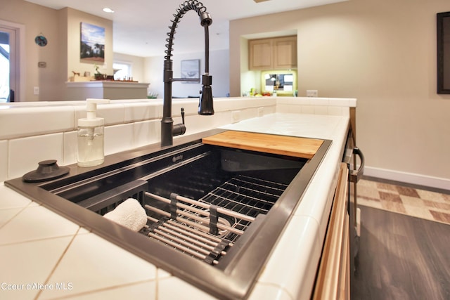 interior details with baseboards, wood finished floors, a sink, and recessed lighting