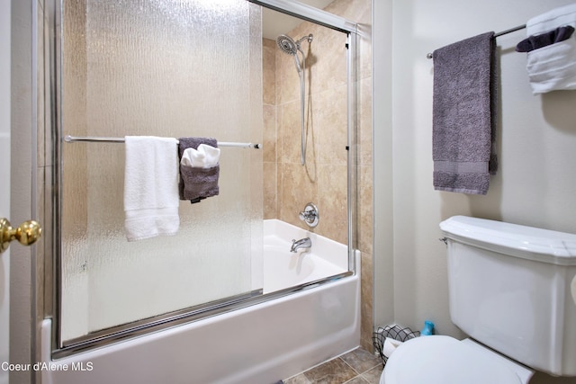 bathroom with toilet and bath / shower combo with glass door