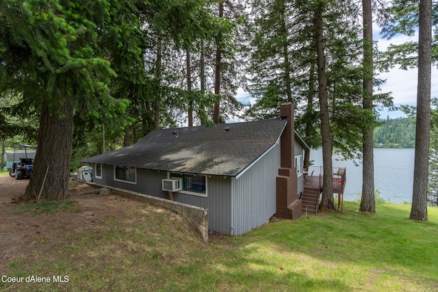 view of side of property featuring a lawn and a deck with water view