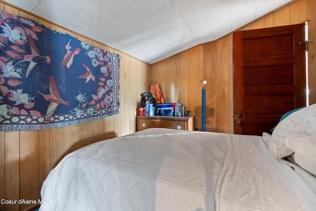 bedroom with wooden walls and lofted ceiling