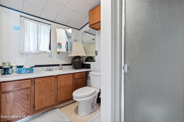 bathroom with vanity, toilet, and lofted ceiling