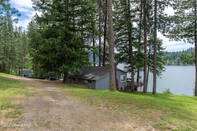 view of side of home featuring a lawn and a water view