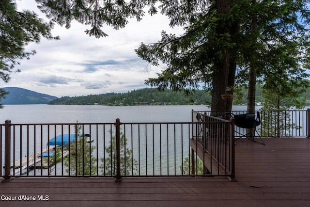 wooden terrace featuring a water and mountain view