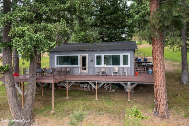 rear view of house with a yard and a wooden deck