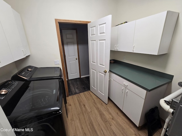 laundry area with cabinets, light wood-type flooring, and independent washer and dryer