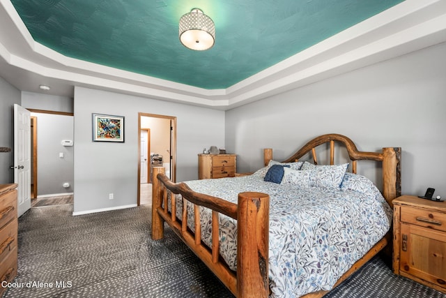 carpeted bedroom with a raised ceiling