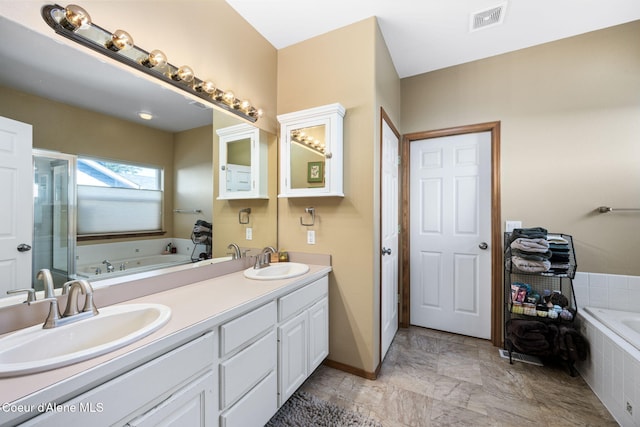 bathroom with vanity and tiled tub