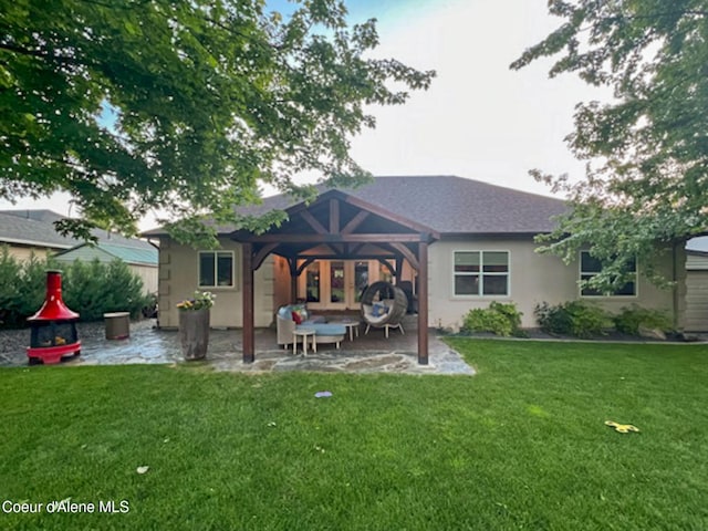 back of property with a yard and a patio area