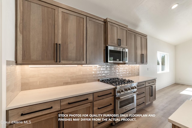 kitchen featuring appliances with stainless steel finishes, backsplash, and light hardwood / wood-style flooring